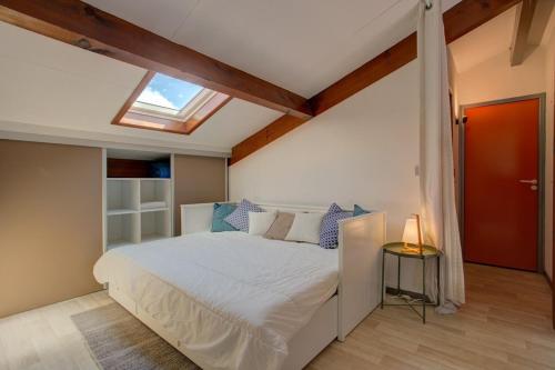 a bedroom with a large bed with a skylight at Biscarrosse Bourg - Duplex avec terrasse classé 3 étoiles in Biscarrosse