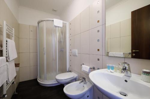 een badkamer met een douche, een wastafel en een toilet bij Hotel Residence Zust in Verbania