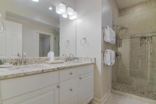 a white bathroom with two sinks and a shower at 4 Silver Moss in Kiawah Island