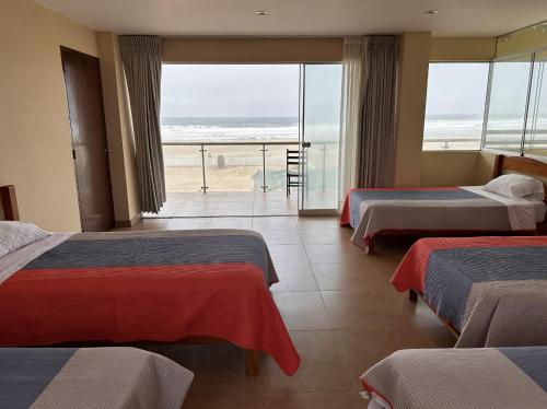 a hotel room with two beds and a view of the beach at YOLO House Beach in Asia