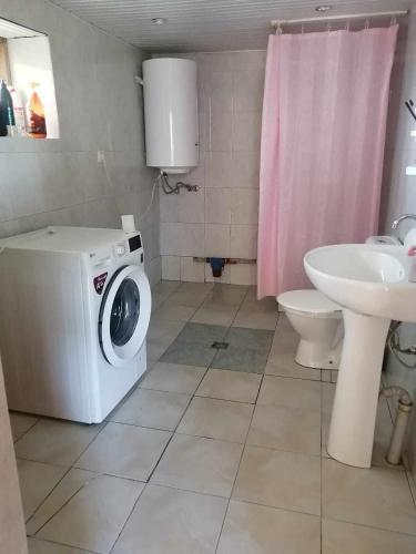 a bathroom with a washing machine and a sink at RUSO'S GuestHouse in Kʼolashi