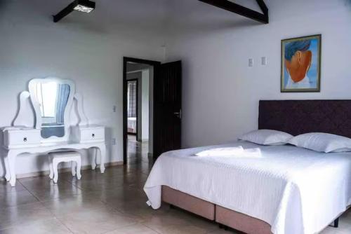 - une chambre avec un lit blanc et une table blanche dans l'établissement Pousada Sabores do Mar Laranjeiras, à Balneário Camboriú