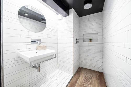 La salle de bains blanche est pourvue d'un lavabo et d'un miroir. dans l'établissement Elegant Marylebone Hideaway, à Londres