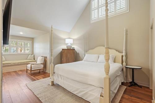 1 dormitorio con 1 cama blanca y 1 silla en 5 Silver Moss, en Kiawah Island