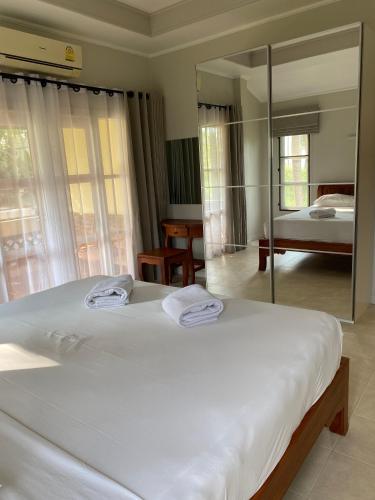 a bedroom with a large white bed and a mirror at Samui Green Life in Bophut 