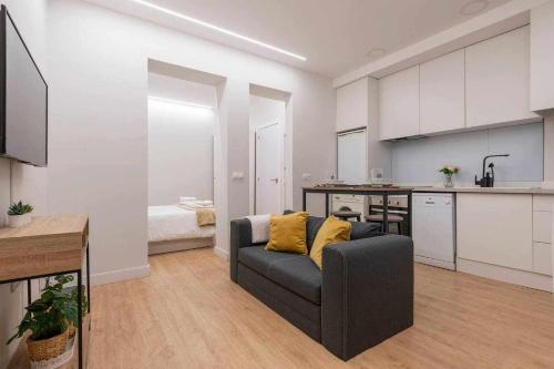 ein Wohnzimmer mit einem Sofa und einer Küche in der Unterkunft Ponzano Foodie Encanto Madrileño in Madrid