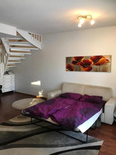 a living room with a bed and a staircase at Lapland Second Home in Rovaniemi