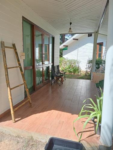 a porch with a ladder and chairs on it at The River Retreat Koh Mak in Ko Mak