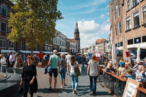 a group of people walking down a busy city street at Bosfluiter in Halle