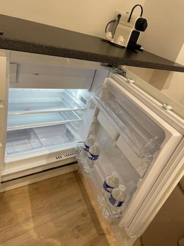 - un réfrigérateur ouvert avec des bouteilles d'eau dans l'établissement Le Cocon de Strasbourg Centre, proche Parlement Européen, à Strasbourg