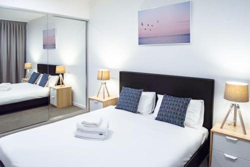 a bedroom with two beds and a mirror at Ideal Cozy 1BR for your Urban Escape in Gabba in Brisbane