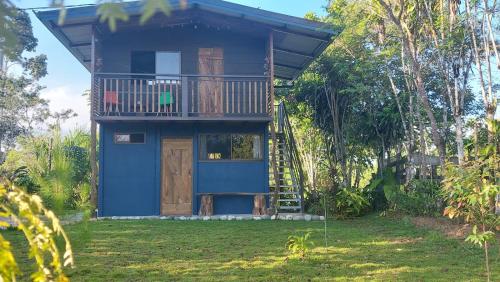 Casa azul con balcón y porche en Cabañita La Montaña de Las Brisas, en San Vito