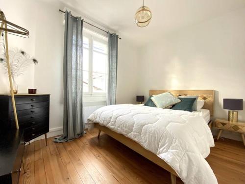 Un dormitorio blanco con una cama y una ventana. en Villa familiale à Arcachon plage, en Arcachon
