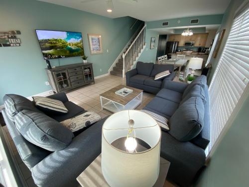 a living room with a blue couch and a tv at Blue Parrot in Gulf Shores