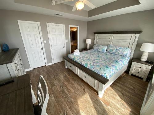 a bedroom with a bed and a dresser and two doors at Blue Parrot in Gulf Shores
