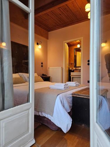 a bedroom with two beds and a sliding glass door at Kallisti Luxury rooms in Nafplio