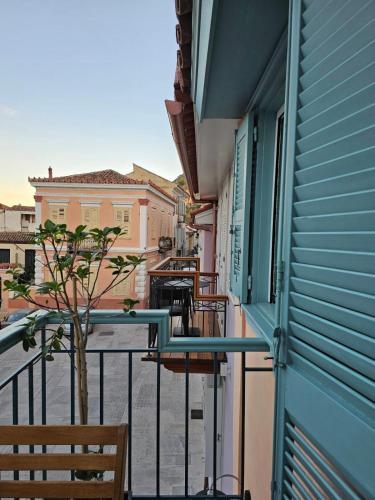 a balcony with chairs and a tree on a street at Kallisti Luxury rooms in Nafplio