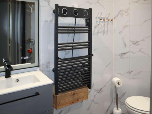 une salle de bain avec toilettes, lavabo et miroir dans l'établissement Studio rénové pour 4, accès skis aux pieds, Les Orres - FR-1-322-51, aux Orres