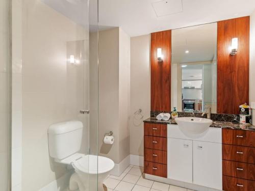 a bathroom with a toilet and a sink and a mirror at Stunning riverview 2BR holiday apt good location in Gold Coast