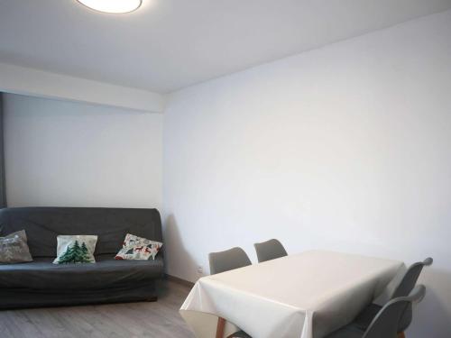 Cette chambre blanche dispose d'une table et d'un canapé. dans l'établissement Studio skis aux pieds pour 4 personnes, cœur de station - FR-1-322-14, aux Orres