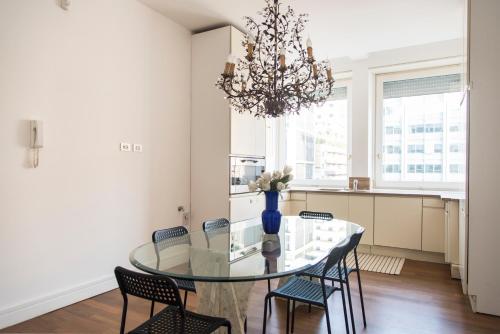 jadalnia ze szklanym stołem i krzesłami w obiekcie Vittore Rooms & Apartment w Mediolanie