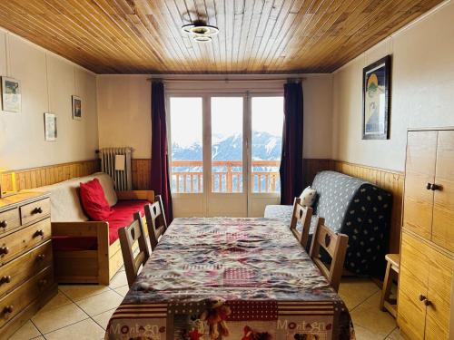 ラルプ・デュエズにあるAppartement Huez, 2 pièces, 4 personnes - FR-1-405-22のテーブルとベッド、窓が備わる客室です。