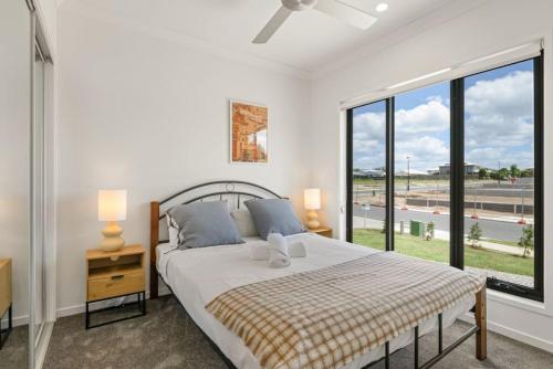 a bedroom with a bed and a large window at 3BR home with cozy interior design in Browns Plains