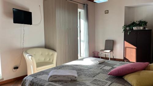 1 dormitorio con 1 cama, 1 silla y TV en Maria Lai 4 pax + 1 letto supplementare, en Giuliano di Roma
