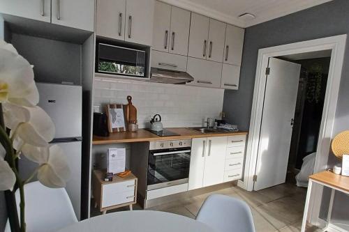 a kitchen with white cabinets and a counter top at Tiny Home on Broadway in Gqeberha