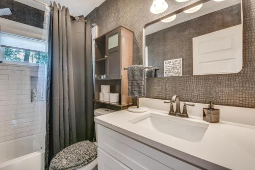 bagno con lavandino e specchio di Modern Atlanta Retreat Private Hot Tub and Yard! ad Atlanta