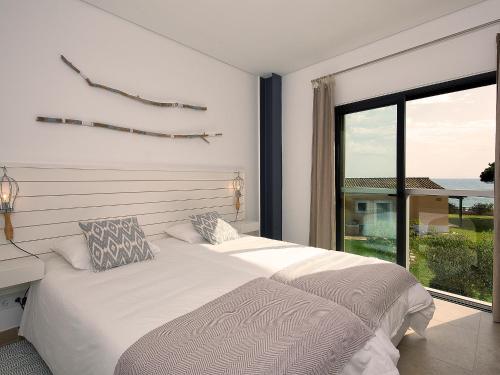 een slaapkamer met twee bedden en een groot raam bij Winter @Prainha in Alvor