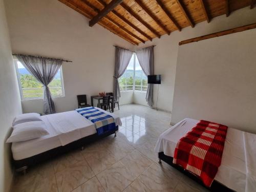 sypialnia z 2 łóżkami i dużym oknem w obiekcie HOSPEDAJE VILLA SAMARA w mieście Guatapé