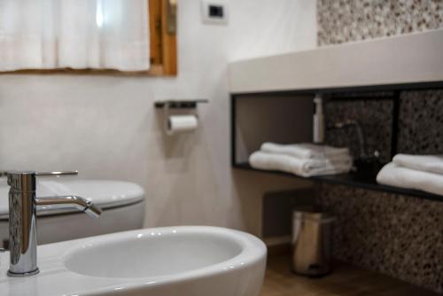 a bathroom with a sink and a toilet and towels at Piccolo Hotel Aurora in Abbadia San Salvatore