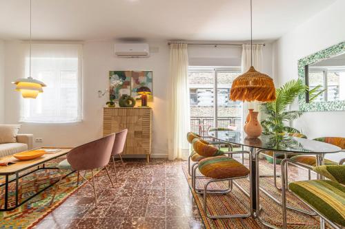 a living room with a glass table and chairs at El Balcón de la Bodega - Luxurious apartment in Jerez with gym in Jerez de la Frontera
