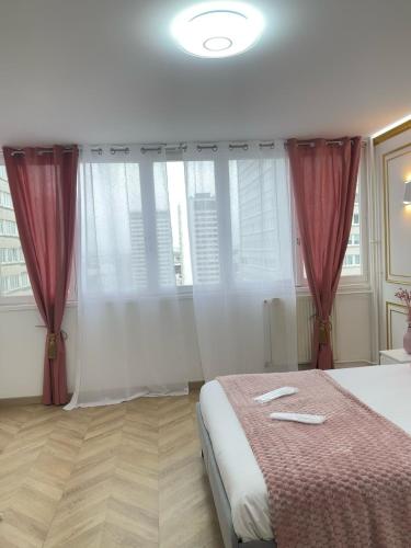a bedroom with a large bed with red curtains at SCI IMMO PARIS PORTE DE CHOISY in Paris