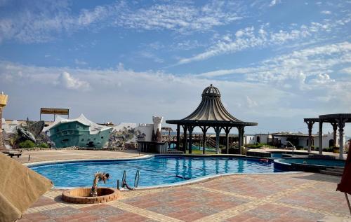 a swimming pool with a gazebo next to a building at Black Prince Hotel in Dahab