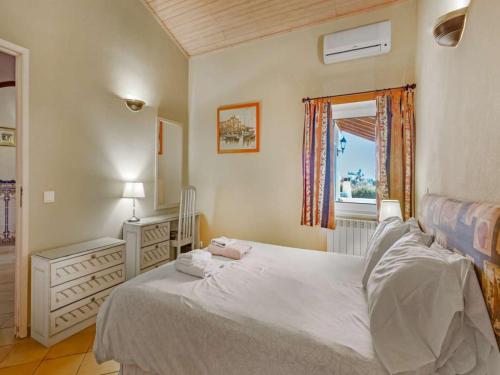 een slaapkamer met een wit bed en een raam bij Stylish Carvoeiro Villa - Short Walk to Resort Centre - Private Pool - Villa Serena - Algarve in Carvoeiro