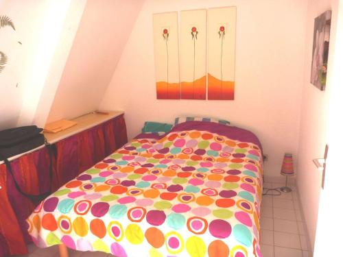 マルセイヤンにあるAppartement Marseillan-Plage, 2 pièces, 4 personnes - FR-1-387-70のベッドルーム1室(カラフルな掛け布団付きのベッド1台付)