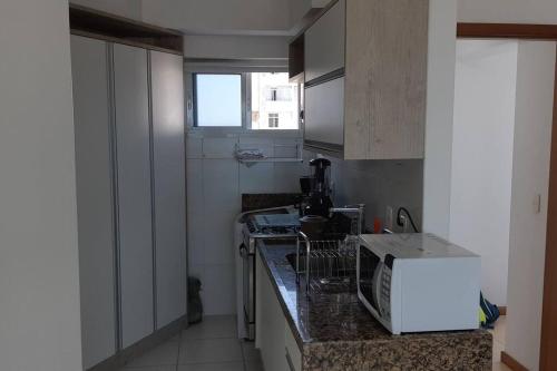 uma cozinha com um lavatório e uma bancada em Apartamento Barra vista Mar em Salvador