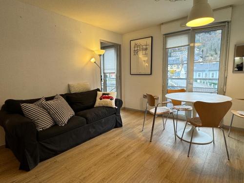 un salon avec un canapé noir et une table dans l'établissement 100m Télécabine ou commerces. 4P, à Cauterets