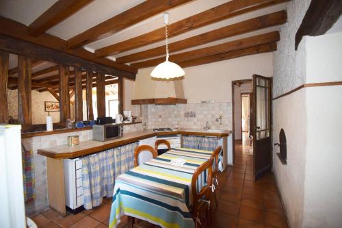 une cuisine avec une table et des chaises dans une pièce dans l'établissement Maison ancienne restaurée - Clévacances 2 Clés, à Lacaussade