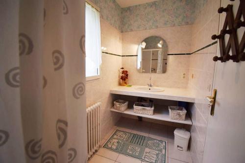 une salle de bain avec un lavabo et un miroir dans l'établissement Maison ancienne restaurée - Clévacances 2 Clés, à Lacaussade