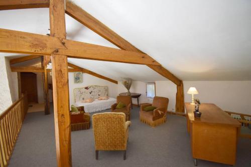 un salon avec un canapé et des chaises dans une pièce dans l'établissement Maison ancienne restaurée - Clévacances 2 Clés, à Lacaussade