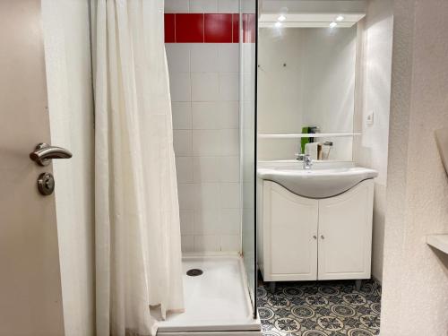 une salle de bain blanche avec un lavabo et une douche dans l'établissement 100m Télécabine ou commerces. 4P, à Cauterets