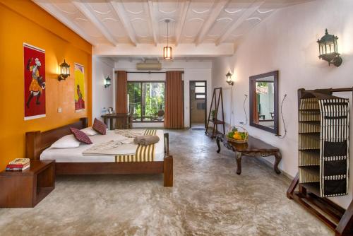 a bedroom with a bed in a room with orange walls at VillaWatuna in Unawatuna