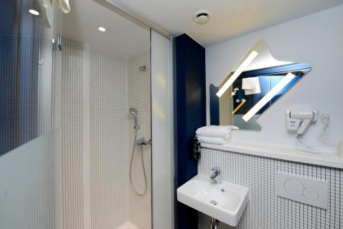 a bathroom with a sink and a shower and a toilet at ibis budget Gent Centrum Dampoort in Ghent