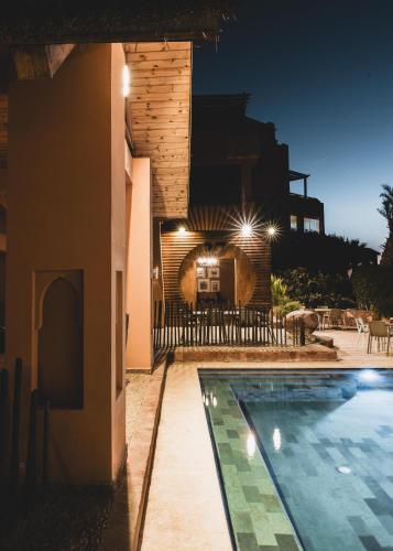 a house with a swimming pool at night at Paradis Plage Surf Yoga & Spa in Taghazout
