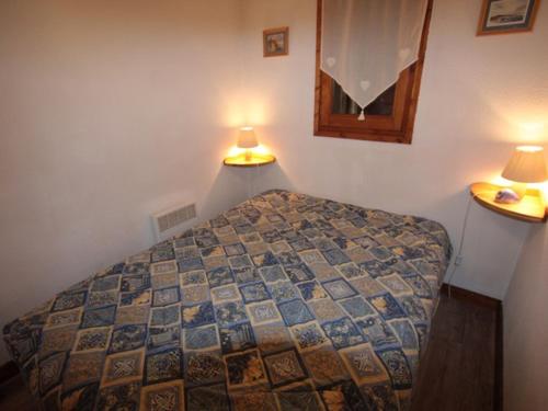 ein Schlafzimmer mit einem Bett und zwei Lampen an der Wand in der Unterkunft Studio Hauteluce, 2 pièces, 4 personnes - FR-1-293-218 in Hauteluce