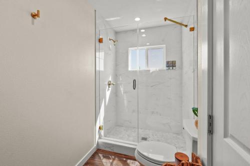 y baño blanco con ducha y aseo. en Captivating 2 Bedroom House W Bbq Near Beach en Los Ángeles
