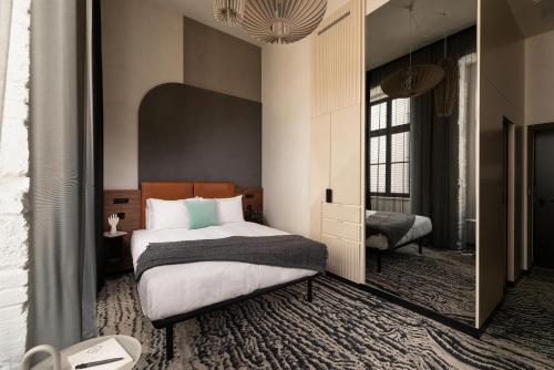 1 dormitorio con cama y espejo grande en Hotel GIN Budapest, en Budapest